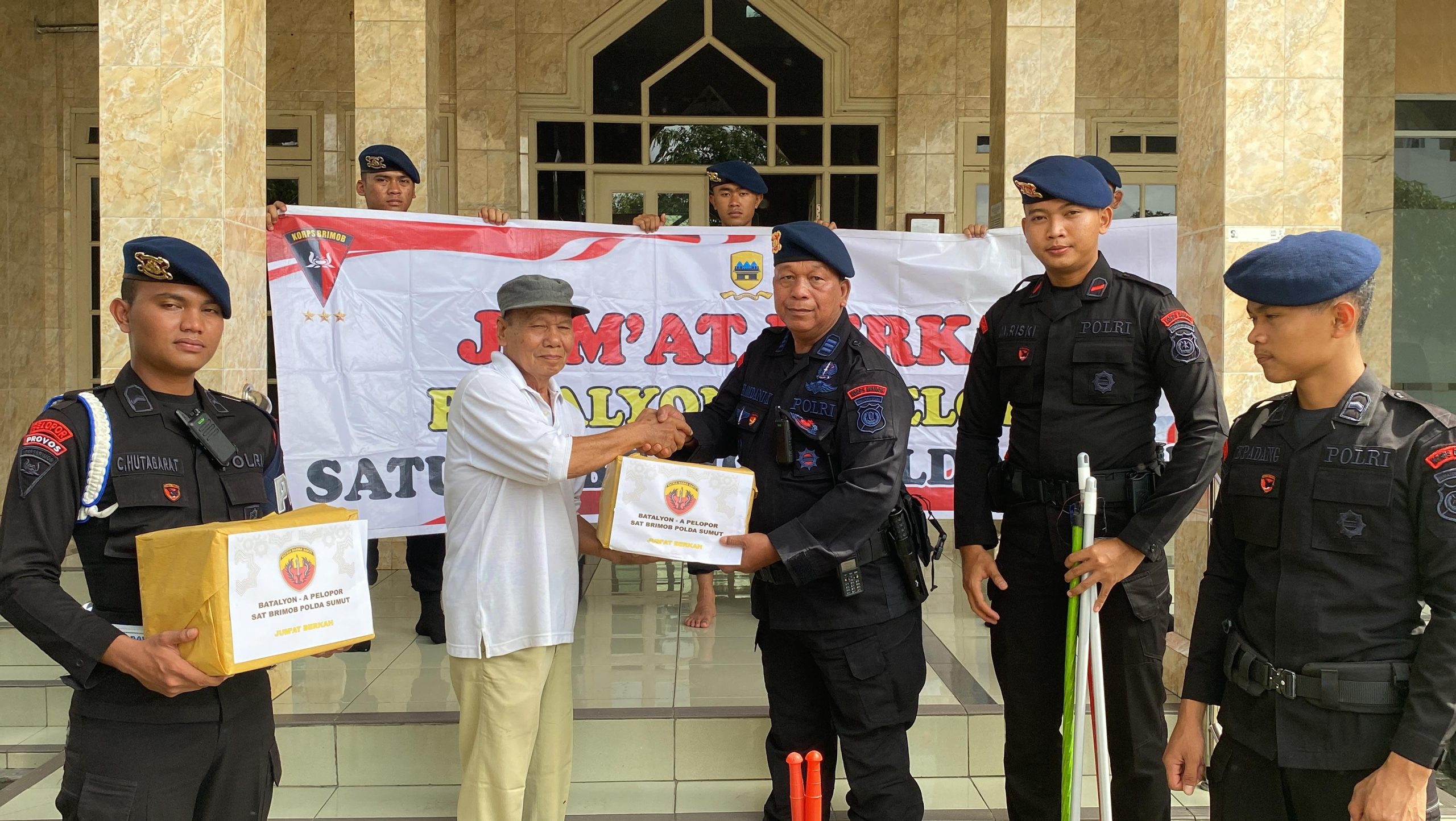 Para personel Brimob dengan penuh semangat dan keikhlasan membagikan paket sembako kepada masyarakat yang membutuhkan.