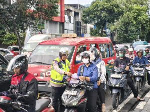 Petugas di lapangan memberikan imbauan tertib lalu lintas kepada pengendara sepeda motor.