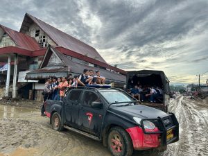 Personel Satuan Brimob Polda Sumatera Utara yang tergabung dalam Posko Utama Garoga, Kecamatan Batang Toru, membantu penjemputan dan pengantaran anak-anak sekolah yang terkendala akses transportasi. (Ist)