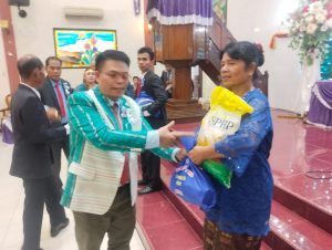 Ketua Panitia Natal, Ir. H. Panggabean, memberikan bingkisan natal berupa sembako kepada jemaat/ruas HKBP Dame.