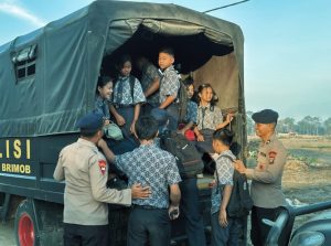 Personel Brimob melakukan penjemputan dan pengantaran anak-anak sekolah di Desa Garoga, Kecamatan Batang Toru, Kabupaten Tapanuli Selatan.