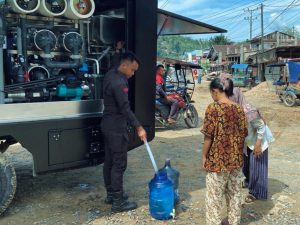 Personel SAR Batalyon A Pelopor Satuan Brimob Polda Sumatera Utara, mendistribusikan air bersih kepada warga dengan menggunakan alat water treatment.