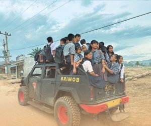 Personel Satuan Brimob, melaksanakan penjemputan dan pengantaran anak-anak sekolah yang terdampak banjir bandang dan tanah longsor.