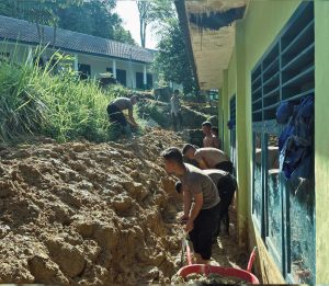 Personel Batalyon A Pelopor Satuan Brimob Polda Sumatera Utara, melakukan pembersihan material lumpur di SMP Negeri 2 Pandan Nauli, Desa Sibuluan Indah, Kecamatan Pandan.