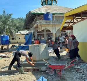 Personel Brimob membantu renovasi sumur Masjid Taqwa Muhammadiyah Garoga untuk ketersediaan air bersih bagi jamaah dan masyarakat sekitar.