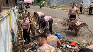 Personel Brimob Kompi-2 Batalyon-C Satuan Brimob Polda Sumatera Utara melaksanakan pembersihan sampah seputaran Pasar.