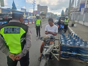 Petugas melakukan pengecekkan surat-surat kendaraan kepada pengendara sepeda motor untuk mencegah pelanggaran pada pelaksanaan Operasi Keselamatan Toba 2026.
