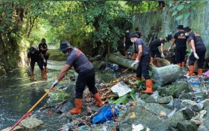 Personel Kompi 2 Batalyon B Satuan Brimob Polda Sumatera Utara kerja bakti membersihkan aliran Sungai Jalan Sisingamangaraja di Kelurahan Kahean, Kecamatan Siantar Utara, Kota Pematangsiantar.