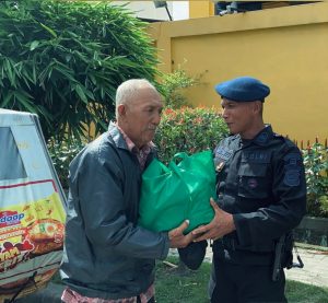 Danton IV Kompi 3 Batalyon A Pelopor, Aiptu Widiarto, membagikan paket sembako kepada masyarakat yang membutuhkan.
