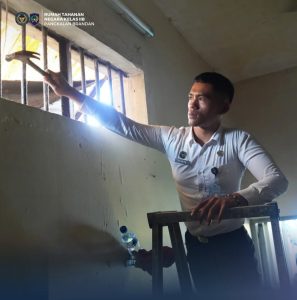 Petugas melakukan pengecekan kondisi tralis pada kamar hunian warga binaan.