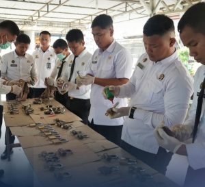 Petugas melakukan pembersihan gembok pada pintu kamar hunian.