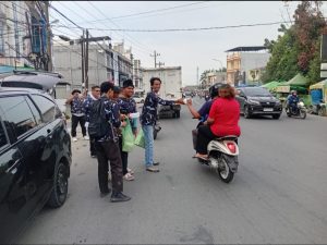 Para rekan juang AMPI menyapa pengendara yang melintas sembari menyerahkan paket takjil untuk berbuka puasa.