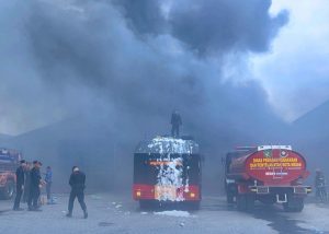 Personel Satuan Brimob Polda Sumatera Utara bersama tim Pemadam Kebakaran Kota Medan, padamkan kebakaran yang terjadi di area pengangkutan MT Trans.