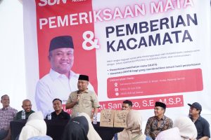 Anggota DPR RI, Sugiat Santoso, saat memberikan kata sambutan pada kegiatan pemeriksaan kesehatan mata dan pembagian kacamata gratis kepada warga di Langkat.