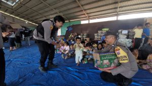 Personel Polres Karo menyalurkan bantuan makanan ringan kepada anak-anak pengungsi warga Desa Kuta Tengah, Kecamatan Simpang Empat, di posko pengungsian.